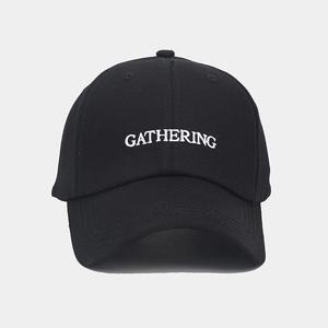 Gros plan détaillé de la broderie GATHERING blanche sur une casquette en coton noir