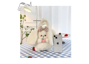 Cute white bunny plush handbag with pink bow and peach detail on a plaid table cloth