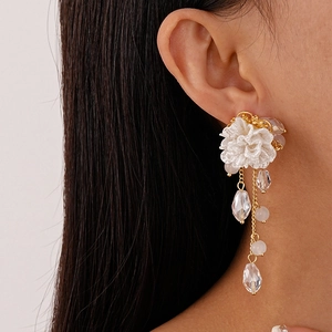 Detail of elegant white flower tassel earring with glass beads on model side profile
