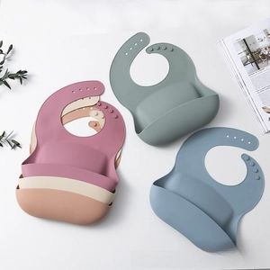 Detail view of five Morandi colored silicone baby bibs with adjustable neck buckles