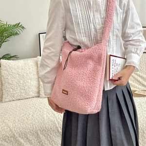 Detalle de bolso bandolera rosa de felpa con cordón de cuero y tejido de piel sintética