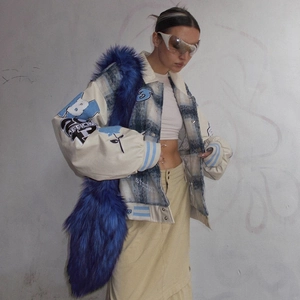 Detail of blue plaid patchwork jacket with embroidery and blue faux fur crossbody bag