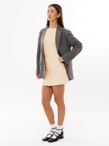 Close-up detail of grey blazer fabric and beige knit dress texture for women