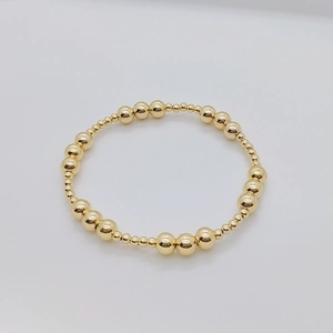 Dettaglio ravvicinato di un bracciale a sfere placcato oro 18 carati con perle lucide