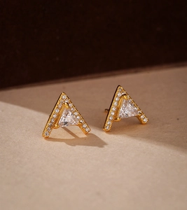 Macro shot of gold V-shaped triangle earrings with pavé set white zircon stones