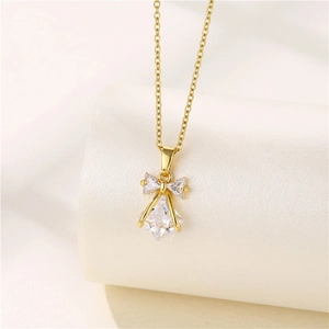 Close-up of golden bow pendant necklace with sparkling clear zircon and diamond details