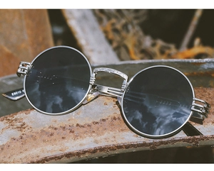 Macro shot of silver steampunk sunglasses with retro engraved temples on industrial metal