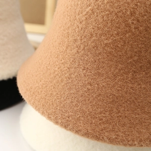Macro detail of the plush faux shearling texture on camel-colored winter bucket hats