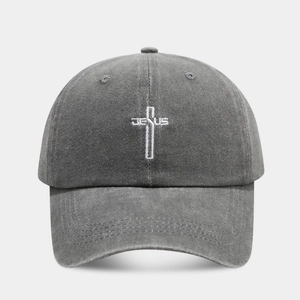 Detailed embroidery of a white cross and Jesus text on a washed grey vintage baseball cap