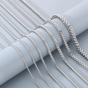 Various thicknesses of silver stainless steel dragon bone chains on a display stand