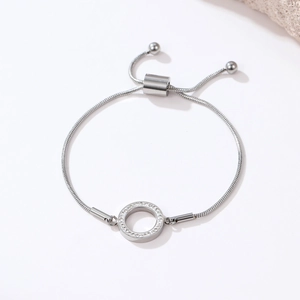 Minimalist silver snake chain bracelet with sparkling zircon ring charm on white background