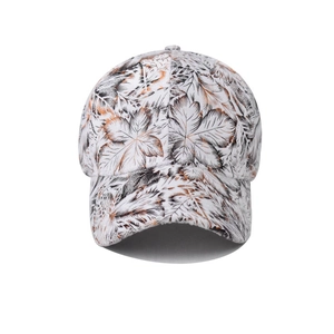 Detailed view of white cotton baseball cap featuring artistic black and tan leaf patterns