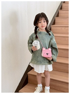 Pink cartoon bear crossbody bag for children shown on a model with adjustable strap