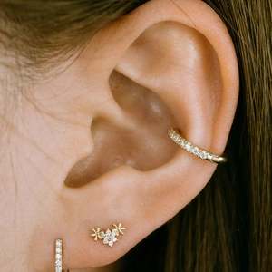 Detailed close-up of gold S925 silver ear cuff and studs with diamonds and pearls
