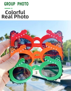 Three pairs of colorful crocodile shaped sunglasses for kids in red, orange, and green