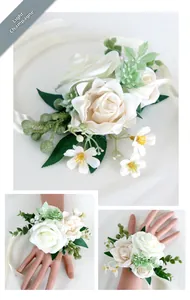 Detail of light champagne faux rose wrist corsage with white ribbons and green foliage