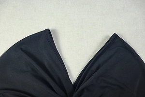 Detailed view of the V-neck stitching and fabric texture on a black two-piece set