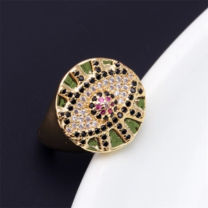 Detailed macro view of gold evil eye signet ring with multicolored zircon and green enamel