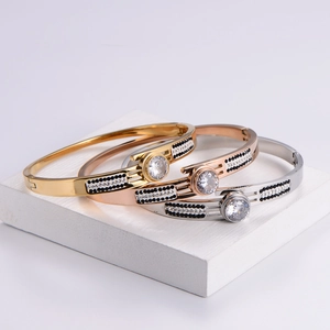 Three-piece stackable bangle set in gold, rose gold, and silver with large round zircon stones