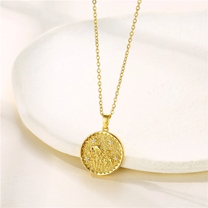 Detailed close-up of a gold coin pendant featuring embossed flower and zircon accents