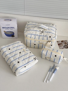 Three-piece quilted cosmetic bag set featuring blue stripes and black star patterns