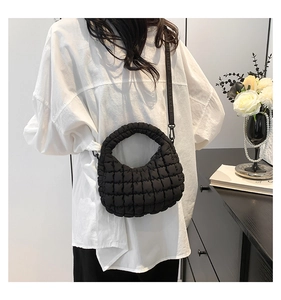 Detail of black quilted cloud handbag with textured nylon fabric and shoulder strap