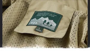 Detail des khakifarbenen Outdoor-Jacken-Ausschnitts mit Netzfutter und Größenetikett