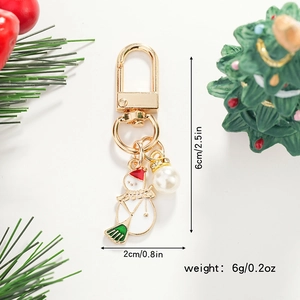 Detailed view of enamel snowman keychain with faux pearl and holiday decorations