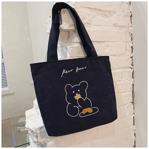 Detail of navy corduroy tote bag featuring a cute embroidered bear and Bear text