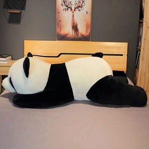 Gros plan détaillé d'une peluche de panda géant couché sur un lit gris confortable