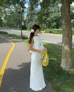 Detailed texture of white pleated cotton sleeveless top and matching maxi skirt set