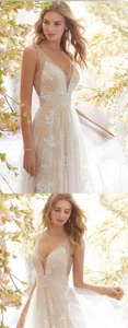 Detailed view of the deep V-neckline with delicate floral lace embroidery on champagne lining