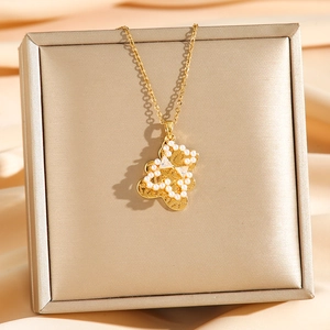 Golden bear pendant necklace with white pearls and zircons on a luxury gift box