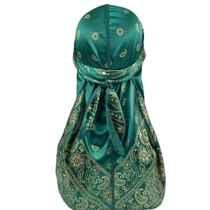 Detailed back view of a dark green satin durag with golden paisley patterns and long tail