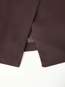 Macro shot of slit detail and twill texture on burgundy blazer with smooth lining
