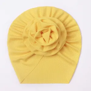 Detailed view of yellow ice silk baby turban featuring a large layered fabric flower