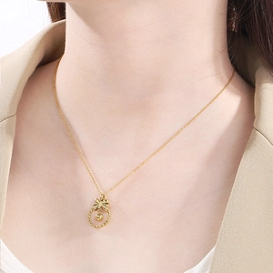 Collier élégant doré avec pendentif nœud papillon et anneau tissé sur un mannequin