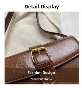 Macro detail of dark brown oil wax leather bag with vintage golden square buckle