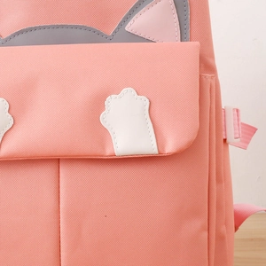 Detail of pink canvas backpack showing cute cat ear designs and smooth fabric texture
