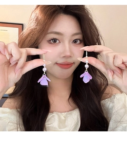 Detail of purple resin flower earrings with pearls and long tassel fringe design