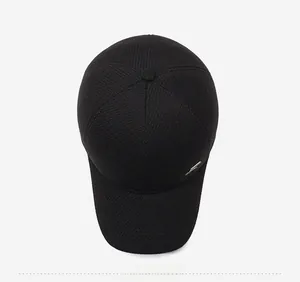 Top view of black textured wool baseball cap with metallic accent and top button detail