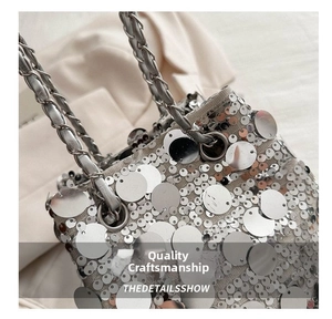 Close-up of shiny silver sequins and metal chain strap on a trendy bucket bag