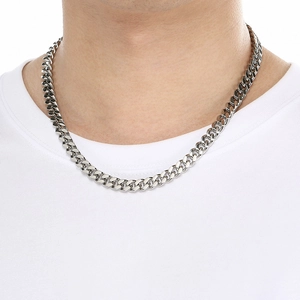 Macro shot of silver stainless steel Cuban link necklace on model showing metallic luster