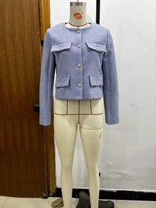Detailed view of lavender tweed jacket featuring intricate texture and golden embossed buttons