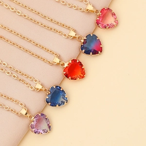 Chic multi-color heart pendant necklaces with golden chains on beige fabric