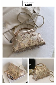 Detail of gold evening bag with shimmering tassel sequins and vintage metal frame clasp
