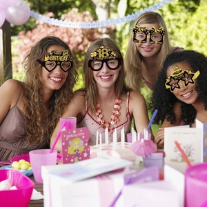 Group of women wearing 18th birthday party paper glasses at a sunny garden celebration