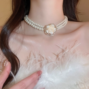 Detail of three-layer pearl choker with camellia shell pendant and diamond accents