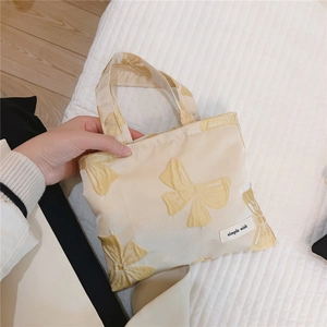 Detail of floral butterfly jacquard fabric and simple wish label on mini canvas bag