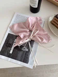 Chouchou en soie rose avec perles brillantes et nœud sur un fond élégant et raffiné